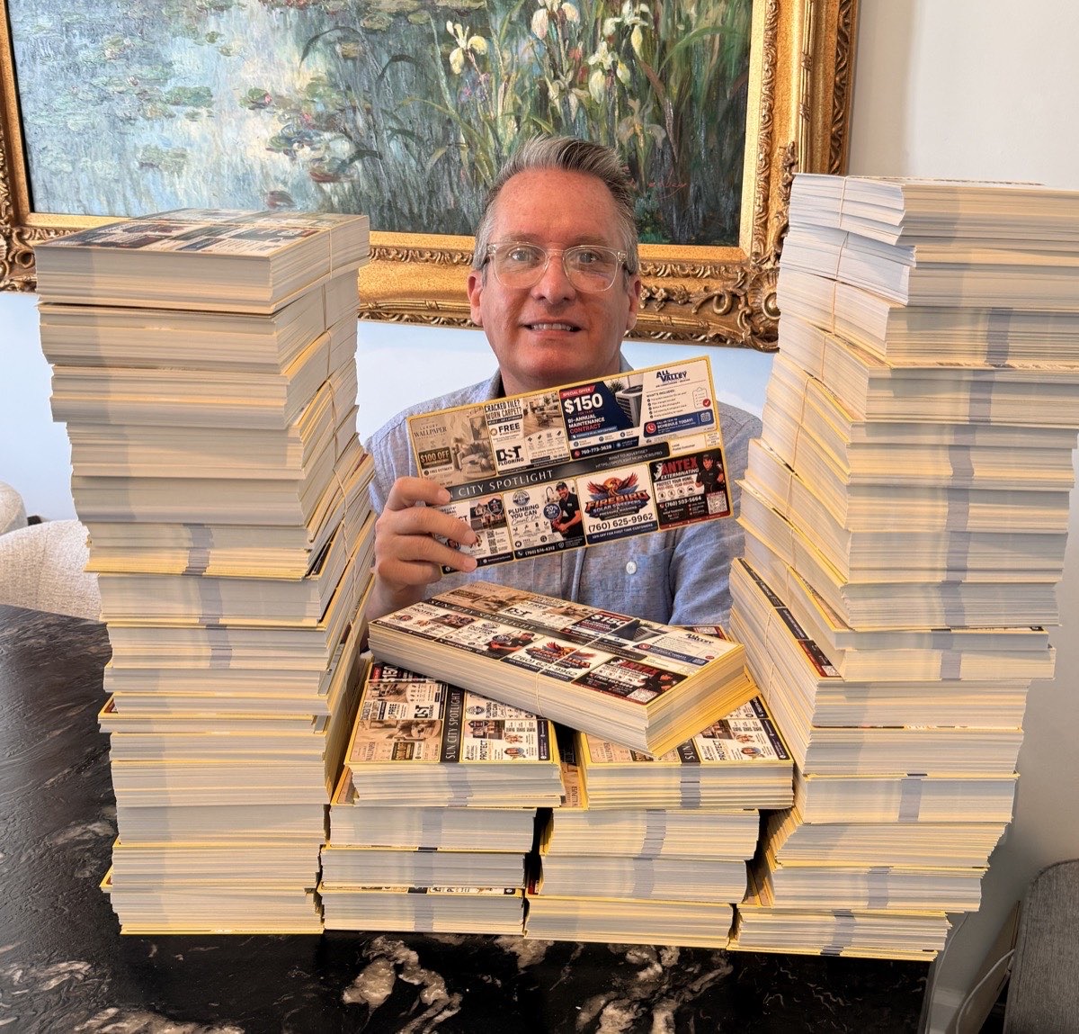 Stacks of printed Spotlight postcards ready to mail, with one card held up to the camera